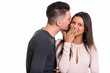 © Ranta Images - Studio shot of young happy couple smiling and in love whispering