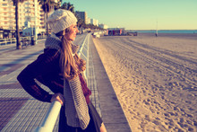 Spain, Cadiz, El Puerto De Santa Maria, Woman With Winter Clothes Looking At Beach