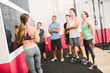 © Matthias Drobeck/Westend61 - CrossFit trainer explaining exercises at blackboard