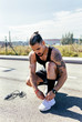 © Marco Govel/Westend61 - Sporty young man tying shoes before training on a road