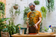 © Cavan Images - Man repotting green plant (Schefflera Umbrella Dwarf Plant)