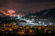 Night ski event with fireworks in Austrian village on snow white ski slope