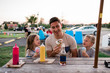 © Cavan Images - Young man and children eat ice cream at picnic table on summer evening