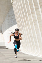 Full Body Of Female Athlete In Sportswear Running On Concrete