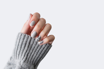 Wall Mural - Females hand in gray knitted sweater with modern manicure close up