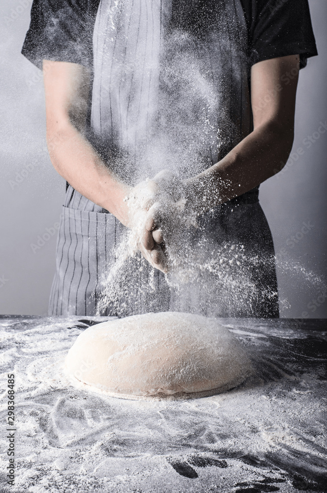 Posypywanie ciasta bochenka chleba mąką osoba w fartuchu piekarz - obrazy, fototapety, plakaty 