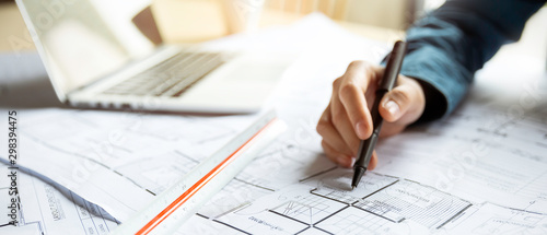 Fotomural Close up woman hand working of Architect sketching project on blueprint at site construction work