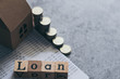 © Koto Amatsukami - Cube block letter of Loan wording with book bank and coin stacks. Idea concept of money, salary or income deposit for home debt payment and mortgage. Business and financial conceptual.