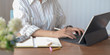 © bongkarn - Cropped shot of young female designer typing on tablet