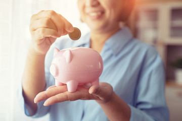 hand putting coin money to piggy bank saving, Close up