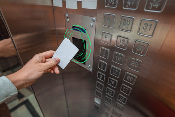 Person using a key card in an elevator