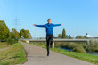 © michaelheim - Joyful woman jumping as she enjoys a winter jog