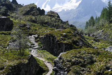 Trekking trail in mountains. Journey to snowy cliffs. The path to goal.