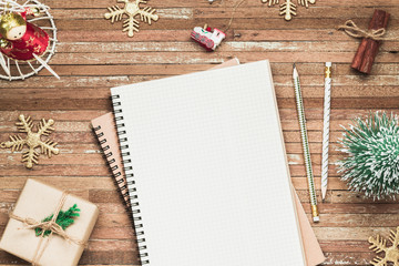 Top view of blank notebook on grunge wood  background with Christmas decorations. Mockup xmas background with notebook for wish list or to do list. Flat lay with copy space.