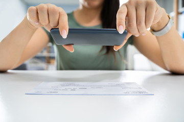 Canvas Print - woman taking photo of cheque to make remote deposit