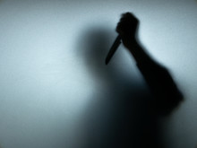 Halloween Concept. Blurred Shadow Of Hand Holding Sharp Knife Behind White Mirror Background. Murder Scene.