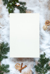 copy space, blank paper on Snow and fir green as background, Christmas, cinnamon sticks and dried clementines with, background 