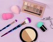 Pastel make-up tool included blender sponge brush powder brush on on purple background