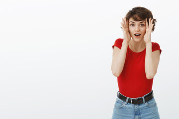 Amused speechless surprised attractive brunette woman pixie short haircut open eyes open mouth gasping stare camera admiration overjoy look camera astonished stand white background