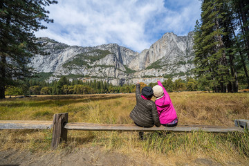 back view of active family of two, mother and daughter enjoying valley and mountain view in yosemite