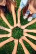 © Viktoriia - Volunteering. Young people volunteers outdoors together hands in fists fighting symbol top view close-up