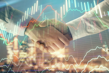 Double exposure of financial chart on cityscape background with two businessmen handshake. Concept of financial analysis and investment opportunities