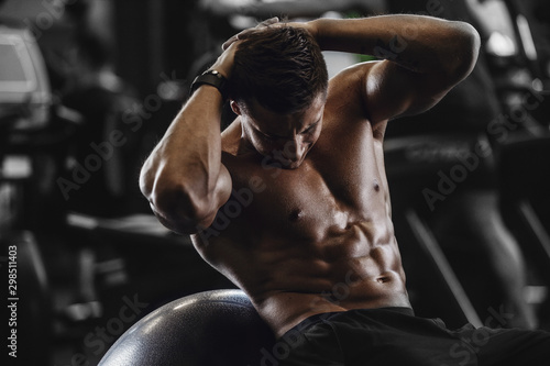 Fotomural Handsome strong athletic men pumping up muscles workout fitness and bodybuilding concept background - muscular bodybuilder fitness men doing abs exercises in gym naked torso