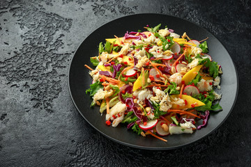 Crab salad with vegetables, radish, carrots, mango, pine nuts and prawn crackers