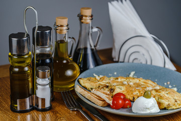 Wall Mural - Scrambled eggs on a plate with toast bread and cherry tomato olive and cheese on the wooden table close up