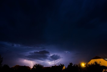 Canvas Print - Beautiful shot of a light storm in the dark sky over a country scenery