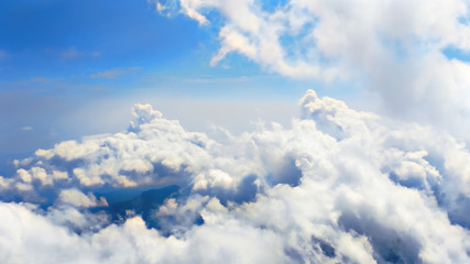 Wall Mural - Flying through heavenly beautiful cloudscape. Picturesque of white fluffy clouds moving softly on the clear blue sky in pure sunshine. Direct view from the cockpit.