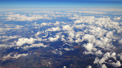 Wall Mural - flying over beautiful heaps of white clouds moving softly from right to left on the bright blue sky,