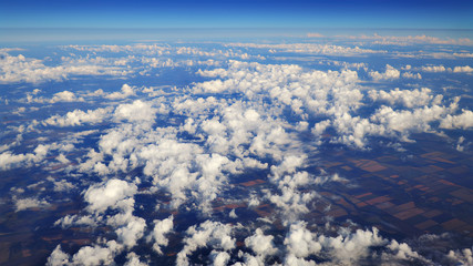 Wall Mural - flying over beautiful heaps of white clouds moving softly from right to left on the bright blue sky,