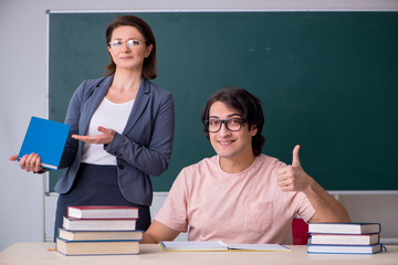 Wall Mural - Old female teacher and male student in the classroom