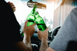 © wutzkoh - Two male friends are celebrating in the car while they are clinking beer bottle together.