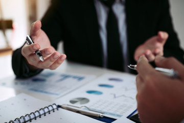 Two business partnership coworkers analysis strategy and gesturing with discussing a financial planning graph and company budget during a budget meeting in office room.