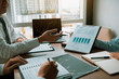 © wutzkoh - Partner colleagues are talking about the results in the document on hand and together analyze the work data about the company's financial statements.