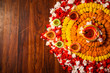 Diwali celebration - Diya oil lamps lit on colorful rangoli of flowers on wooden background