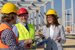 © RGtimeline - Smiling Female Architect, Mature Businessman and Foremen With Table Meeting on Construction Site