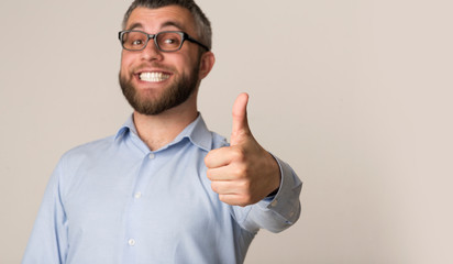 Wall Mural - Excited businessman with toothy smile showing thumb up