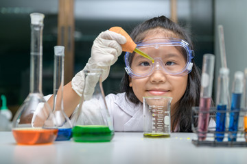 Wall Mural - little scientist wearing safty goggle making experiment.