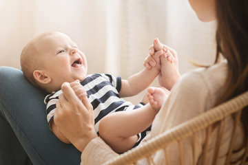 portrait of sweet newborn child lying on mom's lap