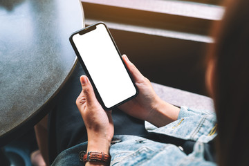 Mockup image of a woman holding black mobile phone with blank desktop screen