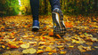 Jogger's feet in blue sneakers close up. A woman athlete run in the autumn forest. Jogging in an amazing autumn forest strewn with fallen leaves