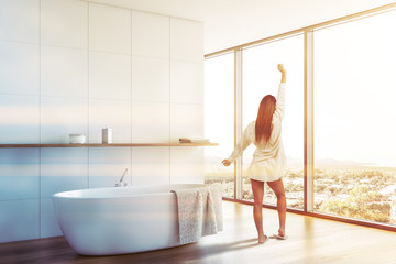 woman in white tile bathroom with shelf