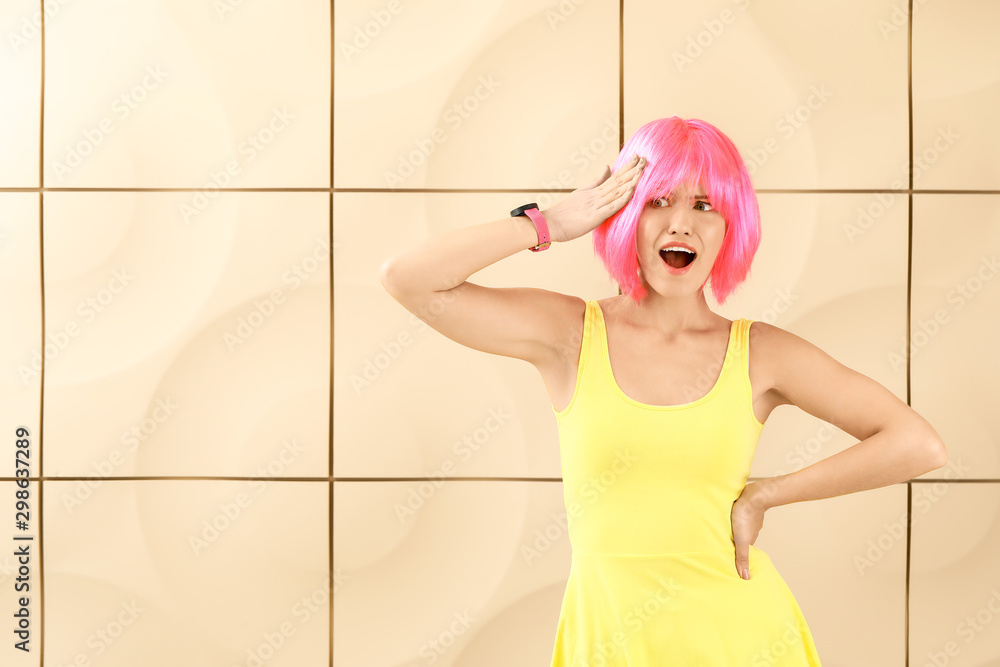 Surprised young woman in bright wig on light background