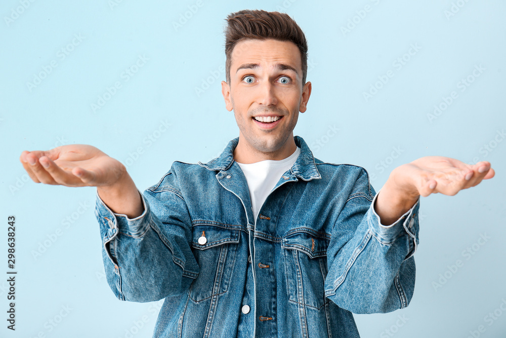 Surprised young man on color background