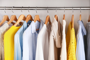 Clothes hanging on rack in wardrobe