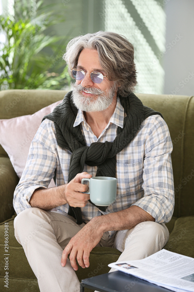 Portrait of handsome senior man drinking tea at home