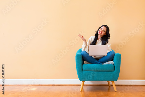 Fotografía Young woman with a laptop computer sitting in a chair